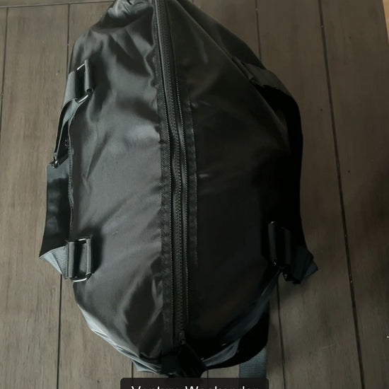 Real packing demonstration of the Venture weekender bag: clothing and overnight essentials, front zip pocket, laptop placement, then zipping and lifting the duffel bag.