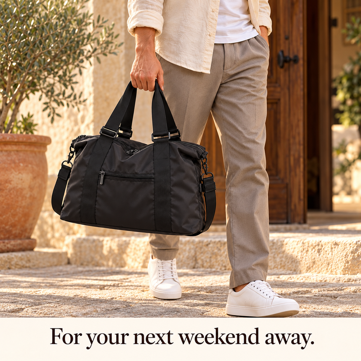 Lifestyle mockup of a man arriving at a guesthouse with the black Torvato Venture weekender duffel. Caption: For your next weekend away.